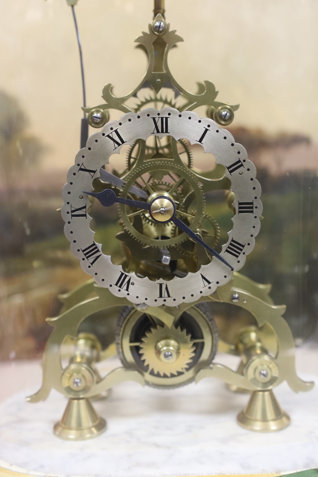 A brass skeleton clock under glass dome on marble base, single fusee, 45 cms high.
